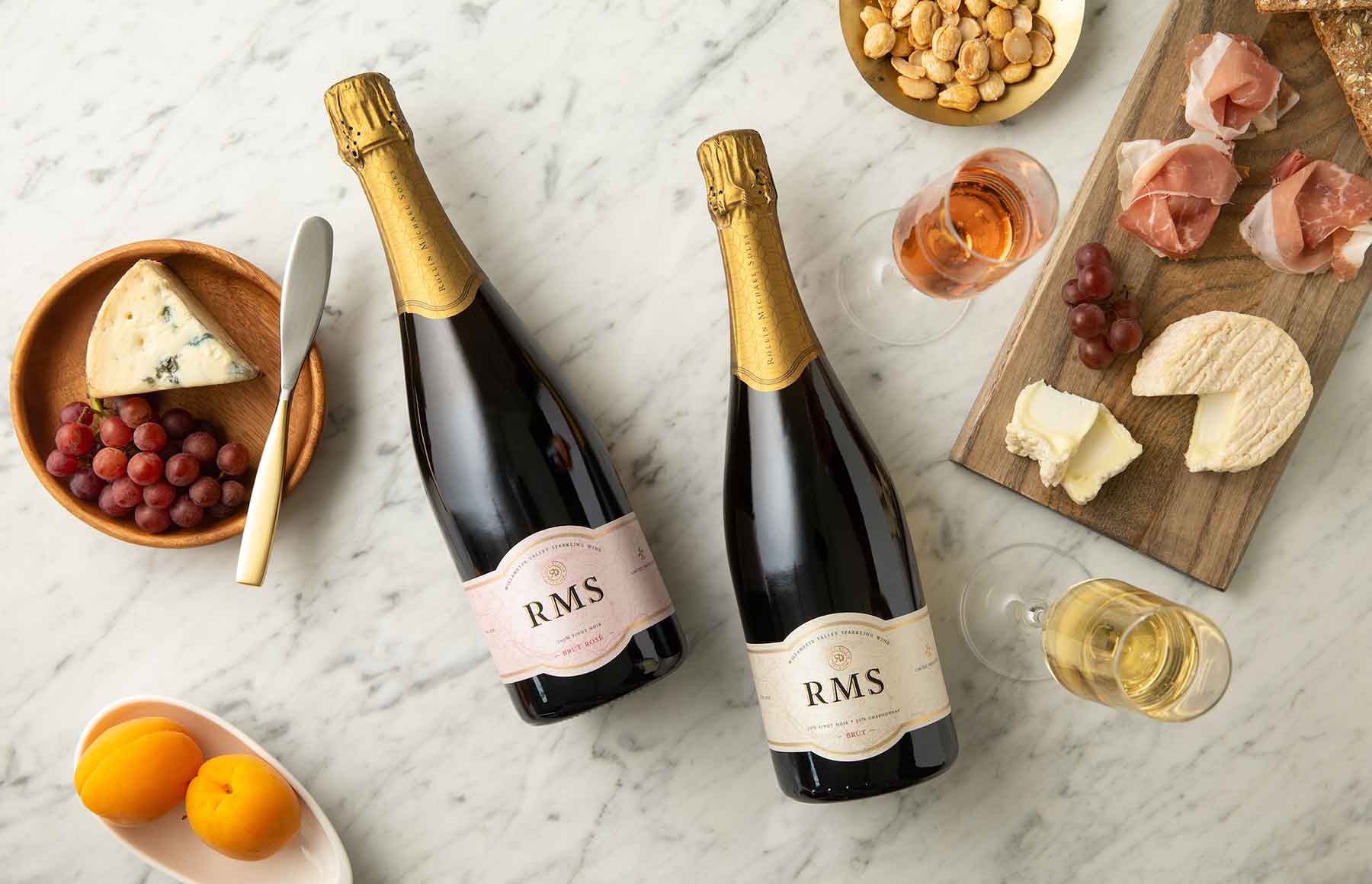 Bottles of RMS Brut with food nearby.